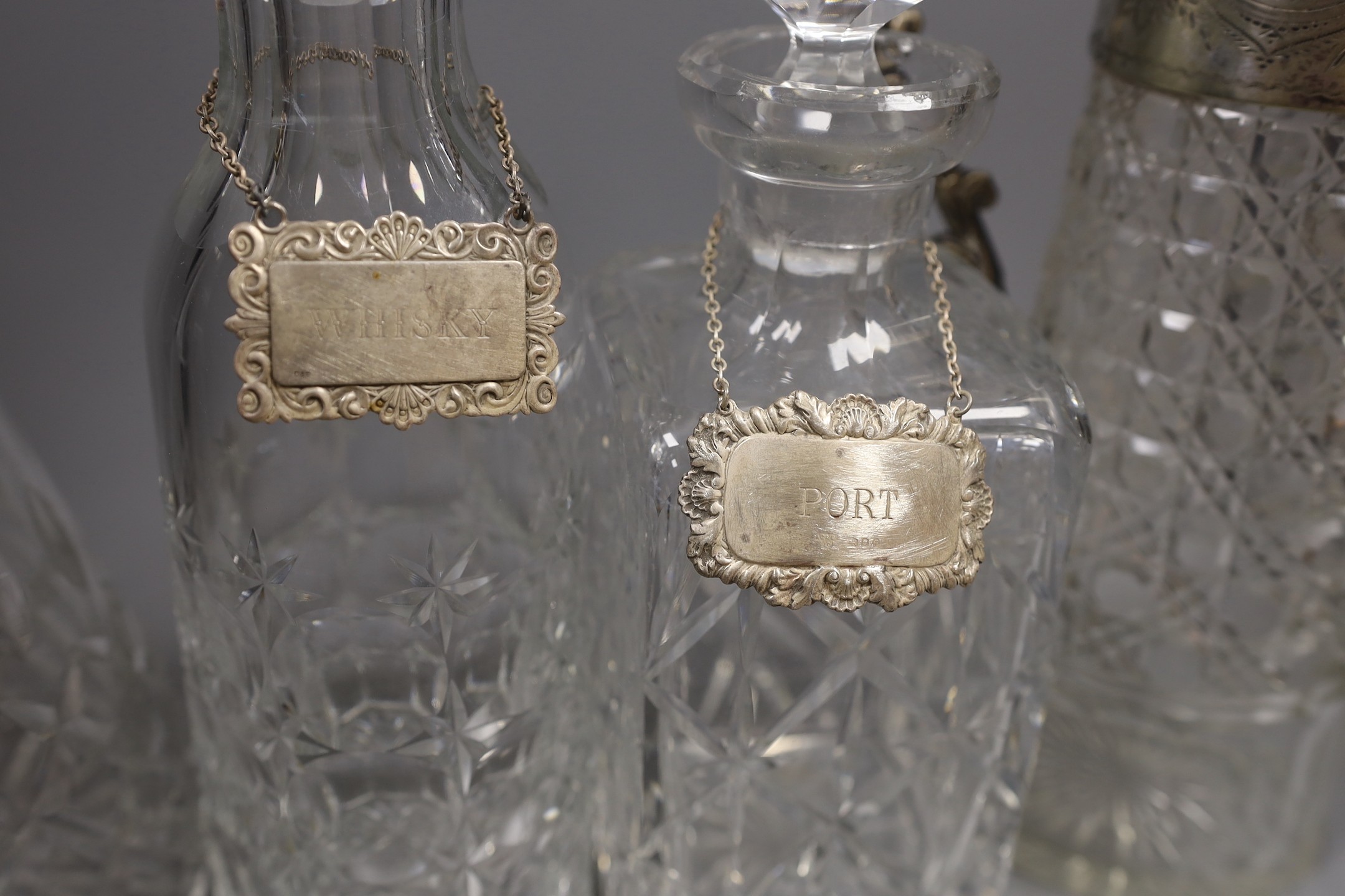 Three various cut glass decanters and a silver plated claret jug-, Claret jug 26 cms high.